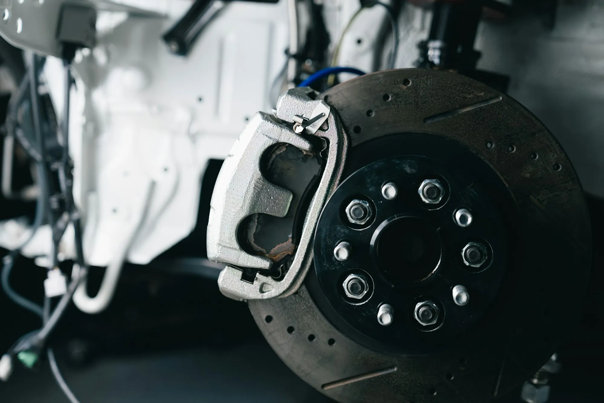 Drilled brake rotor and caliper behind a wheel hub
